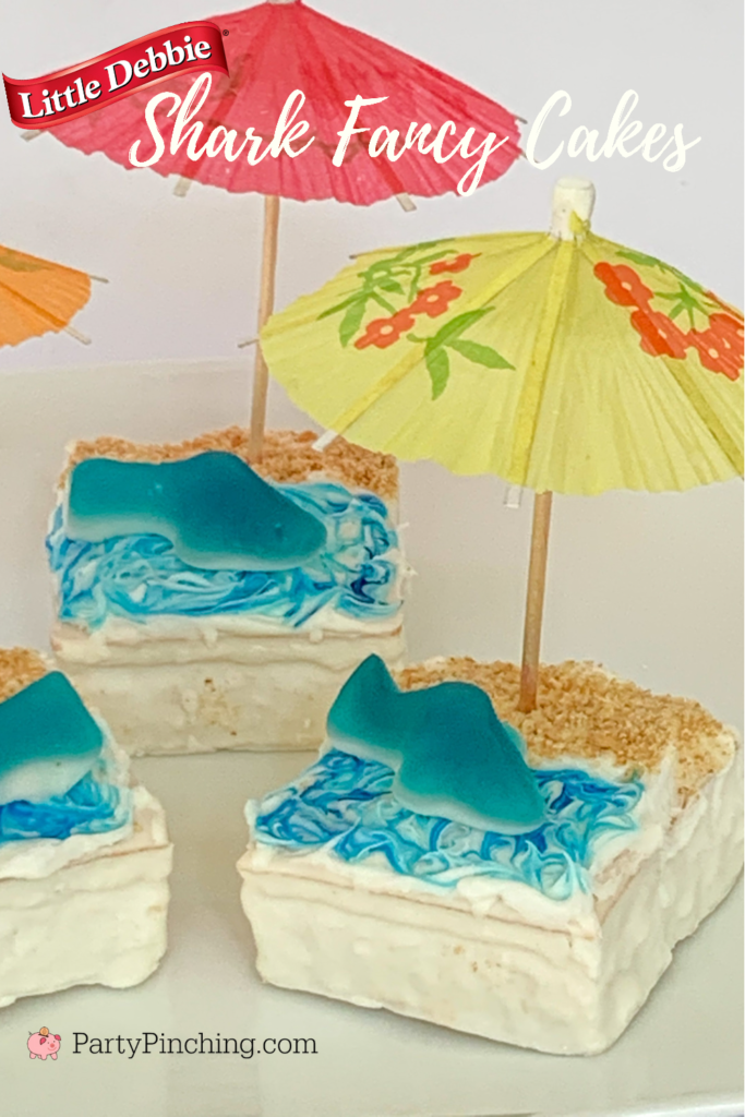 Shark cake, Shark-cuterie Board, best charcuterie board ideas for kids, best charcuterie board, cute charcuterie boards, best fruit trays, summer charcuterie, best summer charcuterie, shark week, shark fruit board, shark food, best shark party ideas, Little Debbie summer, Party Pinching, shark week food, shark week
