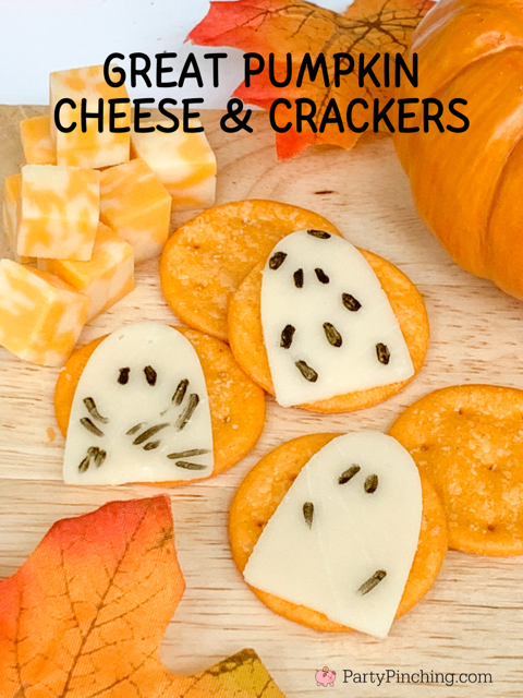 great pumpkin cheese and crackers, charlie brown great pumpkin cheese ghosts, provolone cheese for charcuterie board, black edible marker halloween charcuterie snack grazing board.

