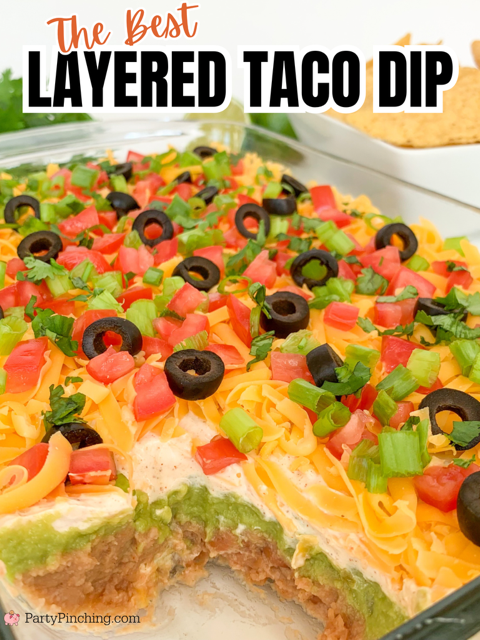 The best layered taco dip, easy best taco dip recipe, hot or cold taco dip recipe, easy appetizer dip for big game superbowl, best picnic potluck ideas for a crowd easy family friendly budget meals, beans guacamole sour cream taco seasoning tomato onion cheese olives lime taco dip