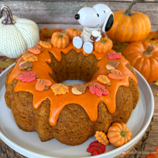 best easy Snoopy Pumpkin Spice Bundt Cake recie, Duncan Hines Snoopy The Great Pumpkin Bundt Cake and Glaze Mix, easy best fall cake, easy best pumpkin spice cake for fall, sweater weather Snoopy, Snoopy with a sweater, how to make Snoopy sweater with mini pumpkins and latte, fall decorated bundt cake with icing leaves and Trader Joe's chocolate pumpkins