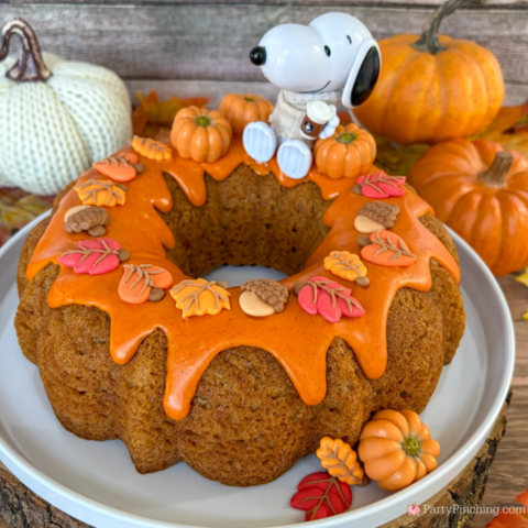 best easy Snoopy Pumpkin Spice Bundt Cake recie, Duncan Hines Snoopy The Great Pumpkin Bundt Cake and Glaze Mix, easy best fall cake, easy best pumpkin spice cake for fall, sweater weather Snoopy, Snoopy with a sweater, how to make Snoopy sweater with mini pumpkins and latte, fall decorated bundt cake with icing leaves and Trader Joe's chocolate pumpkins