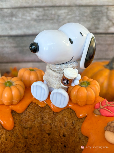best easy Snoopy Pumpkin Spice Bundt Cake recie, Duncan Hines Snoopy The Great Pumpkin Bundt Cake and Glaze Mix, easy best fall cake, easy best pumpkin spice cake for fall, sweater weather Snoopy, Snoopy with a sweater, how to make Snoopy sweater with mini pumpkins and latte, fall decorated bundt cake with icing leaves and Trader Joe's chocolate pumpkins