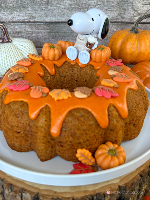 best easy Snoopy Pumpkin Spice Bundt Cake recie, Duncan Hines Snoopy The Great Pumpkin Bundt Cake and Glaze Mix, easy best fall cake, easy best pumpkin spice cake for fall, sweater weather Snoopy, Snoopy with a sweater, how to make Snoopy sweater with mini pumpkins and latte, fall decorated bundt cake with icing leaves and Trader Joe's chocolate pumpkins