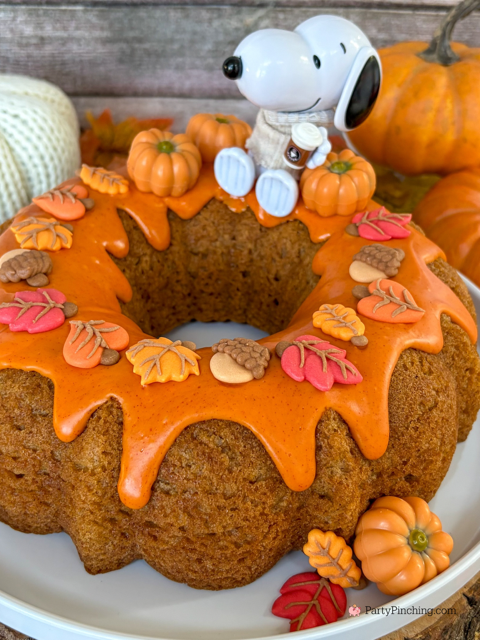 best easy Snoopy Pumpkin Spice Bundt Cake recie, Duncan Hines Snoopy The Great Pumpkin Bundt Cake and Glaze Mix, easy best fall cake, easy best pumpkin spice cake for fall, sweater weather Snoopy, Snoopy with a sweater, how to make Snoopy sweater with mini pumpkins and latte, fall decorated bundt cake with icing leaves and Trader Joe's chocolate pumpkins