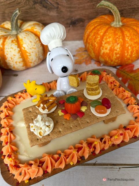 Snoopy's Thanksgiving Dinner Cake, Snoopy's Thanksgiving Feast, Snoopy Trader Joe's Mini Cake, Trader Joe's Mini Thanksgiving Cake, A Charlie Brown Thanksgiving, Snoopy, Charlie Brown, Woodstock, Jelly beans popcorn pretzels toast Thanksgiving dinner, easy no bake Thanksgiving dessert, Thanksgiving ideas for kids, best easy Thanksgiving recipes