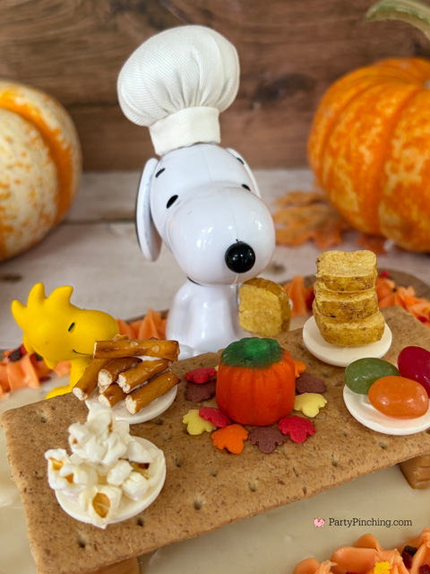 Snoopy's Thanksgiving Dinner Cake, Snoopy's Thanksgiving Feast, Snoopy Trader Joe's Mini Cake, Trader Joe's Mini Thanksgiving Cake, A Charlie Brown Thanksgiving, Snoopy, Charlie Brown, Woodstock, Jelly beans popcorn pretzels toast Thanksgiving dinner, easy no bake Thanksgiving dessert, Thanksgiving ideas for kids, best easy Thanksgiving recipes